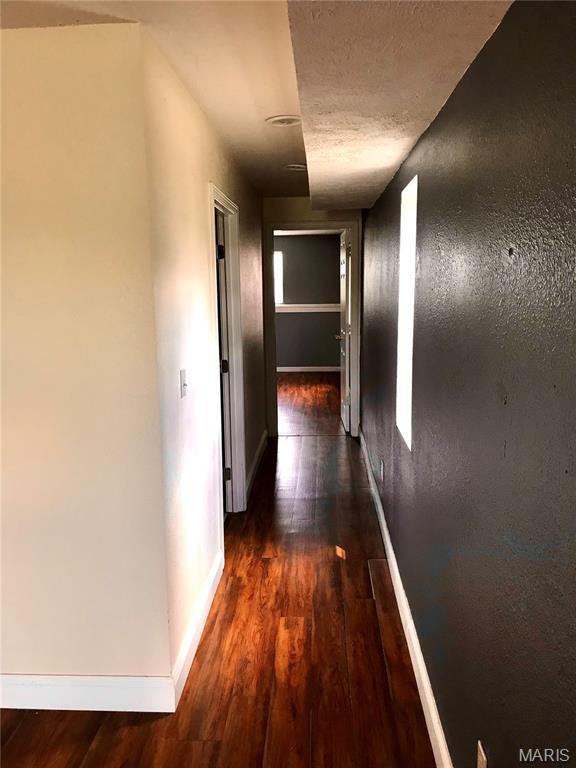 1462 Windle Rd, Cuba, MO 65453 - hallway with dark wood-style flooring and a textured ceiling