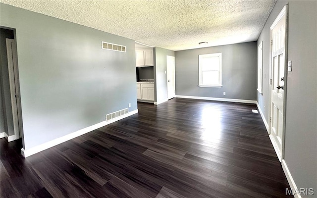 4404 Saint Leo Ln, Saint Ann, MO 63074 - empty room featuring a textured ceiling and dark wood-type flooring