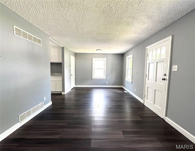 4404 Saint Leo Ln, Saint Ann, MO 63074 - unfurnished living room with dark wood-style floors and a textured ceiling