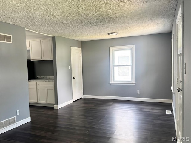 4404 Saint Leo Ln, Saint Ann, MO 63074 - unfurnished room featuring a textured ceiling and dark wood-type flooring