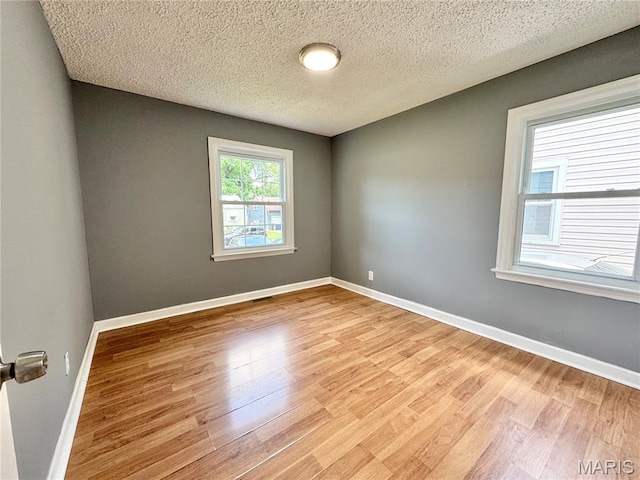 4404 Saint Leo Ln, Saint Ann, MO 63074 - spare room with light wood-type flooring and a textured ceiling
