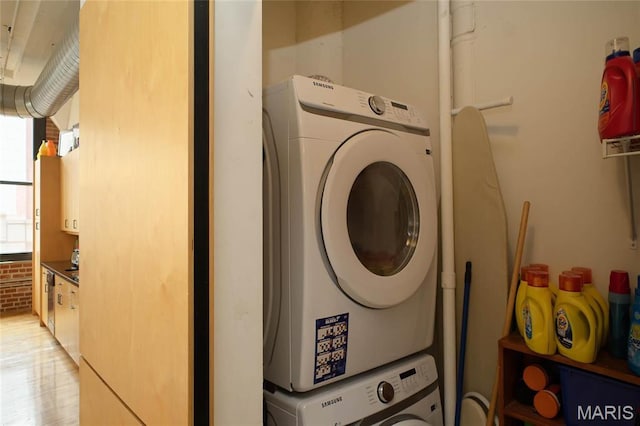1010 Saint Charles St Unit 802, Saint Louis, MO 63101 - washroom featuring stacked washing machine and dryer and light wood-type flooring