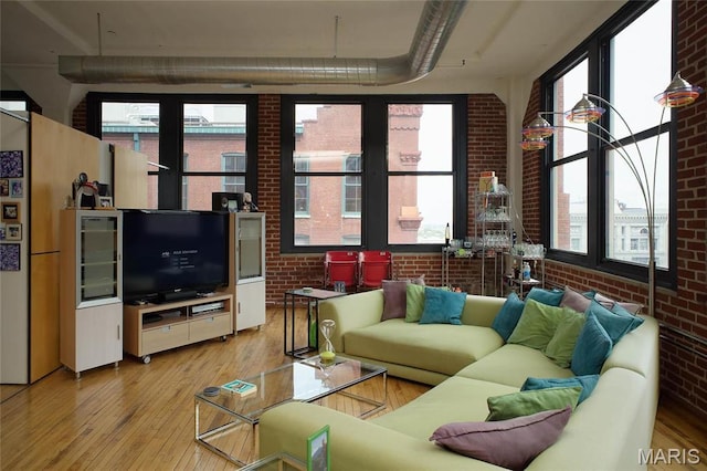 1010 Saint Charles St Unit 802, Saint Louis, MO 63101 - living room with brick wall, light wood-type flooring, and plenty of natural light