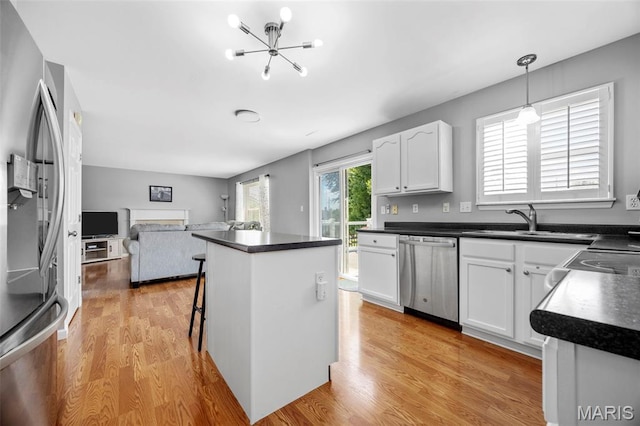 2330 Eagle Pines Dr, Saint Charles, MO 63303 - kitchen with appliances with stainless steel finishes, dark countertops, open floor plan, and white cabinetry