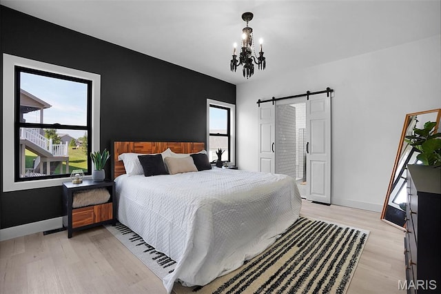 2803 Poolbrook Way, Washington, MO 63090 - bedroom featuring a chandelier, a barn door, light wood-style floors, and multiple windows