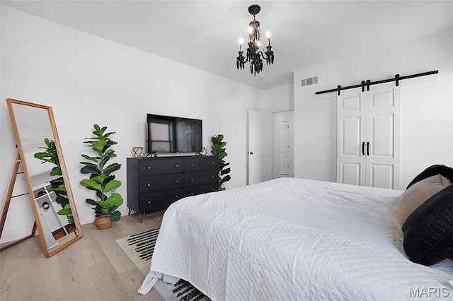 2803 Poolbrook Way, Washington, MO 63090 - bedroom with a barn door, wood finished floors, and a chandelier