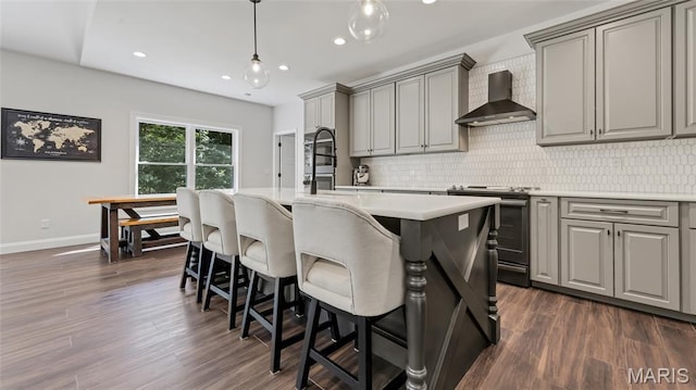 5065 Fox Bridge Rd, Wildwood, MO 63069 - kitchen featuring wall chimney range hood, stove, gray cabinets, decorative backsplash, and recessed lighting