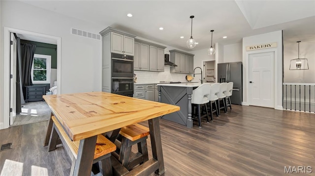 5065 Fox Bridge Rd, Wildwood, MO 63069 - kitchen with gray cabinets, black appliances, backsplash, light countertops, and wall chimney exhaust hood