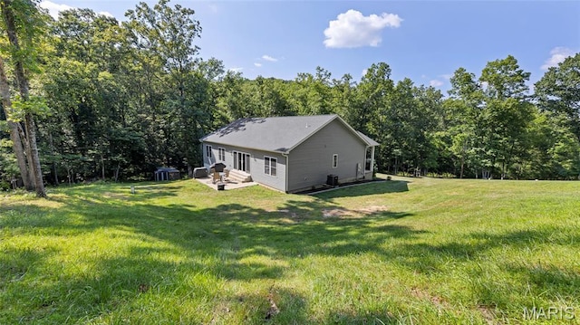 5065 Fox Bridge Rd, Wildwood, MO 63069 - view of side of property with a lawn, a view of trees, and a patio area