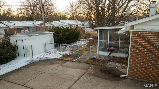 2480 Cambridge Dr, Florissant, MO 63033 - snow covered patio featuring a sunroom and a shed