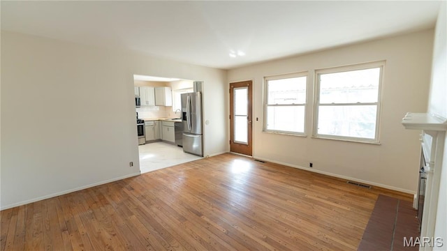 2480 Cambridge Dr, Florissant, MO 63033 - unfurnished living room featuring light wood-style flooring and a sink