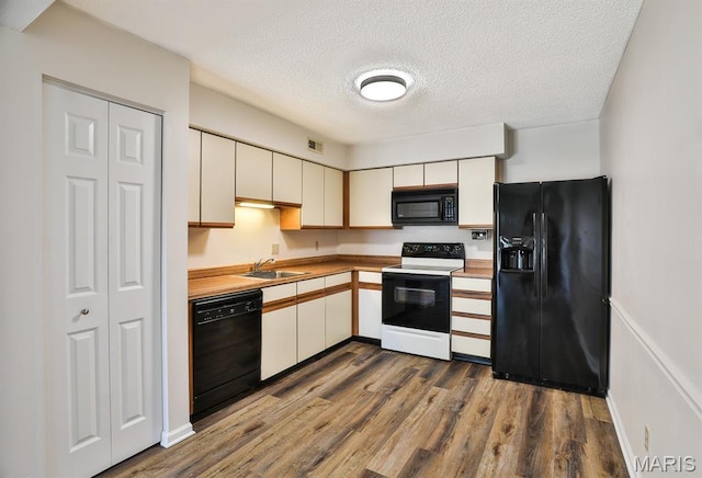 160 Jubilee Hill Dr Unit G, Grover, MO 63040 - kitchen with black appliances, a textured ceiling, dark wood-style floors, white cabinetry, and light countertops