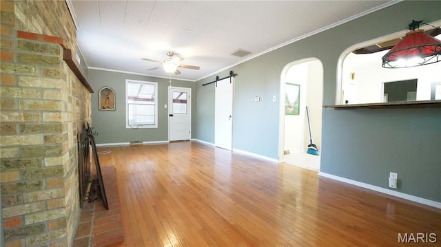 18937 Wayne Route D, Wappapello, MO 63966 - unfurnished living room with hardwood / wood-style floors, arched walkways, a ceiling fan, a barn door, and ornamental molding