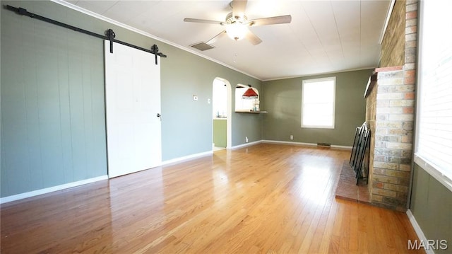 18937 Wayne Route D, Wappapello, MO 63966 - spare room featuring a ceiling fan, light wood-style flooring, arched walkways, ornamental molding, and a barn door