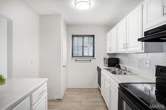 2449 Forest Shadows Dr, Saint Louis, MO 63136 - kitchen featuring black appliances, light wood-style flooring, light countertops, tasteful backsplash, and a textured ceiling