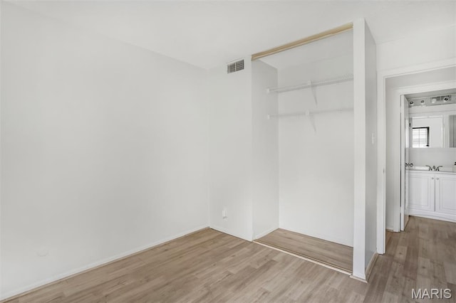 2449 Forest Shadows Dr, Saint Louis, MO 63136 - unfurnished bedroom with light wood finished floors and a closet