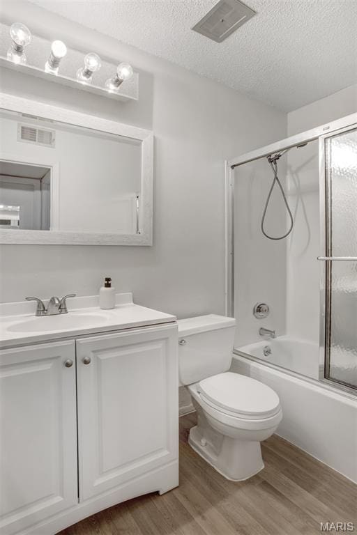 2449 Forest Shadows Dr, Saint Louis, MO 63136 - bathroom with wood finished floors, vanity, a textured ceiling, and combined bath / shower with glass door