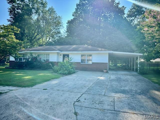823 Sycamore St, New Madrid, MO 63869 - ranch-style house featuring concrete driveway, an attached carport, and brick siding
