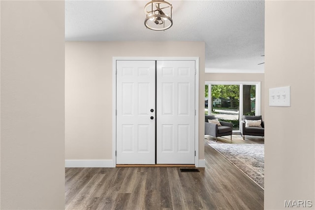 1618 Clock Tower Dr, Saint Louis, MO 63138 - entrance foyer featuring wood finished floors, a chandelier, and a textured ceiling
