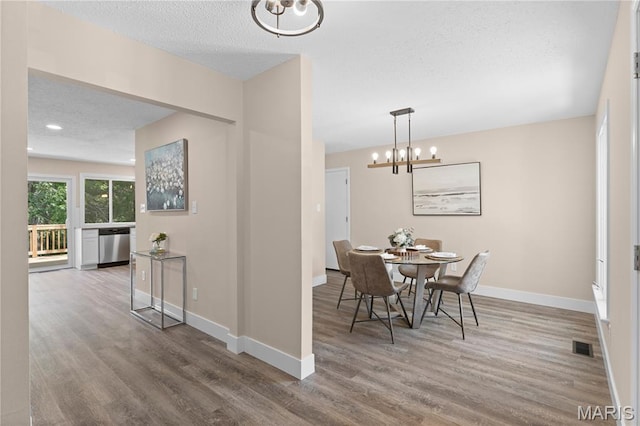 1618 Clock Tower Dr, Saint Louis, MO 63138 - dining space featuring a textured ceiling, wood finished floors, and a chandelier