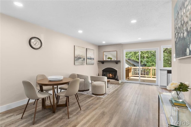 1618 Clock Tower Dr, Saint Louis, MO 63138 - dining room with a fireplace, wood finished floors, recessed lighting, and a textured ceiling