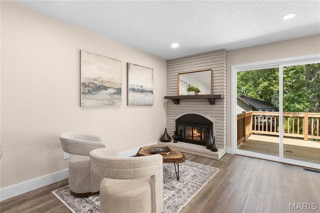 1618 Clock Tower Dr, Saint Louis, MO 63138 - living area featuring a brick fireplace, a textured ceiling, wood finished floors, and recessed lighting