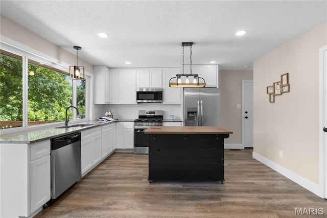 1618 Clock Tower Dr, Saint Louis, MO 63138 - kitchen with appliances with stainless steel finishes, white cabinetry, butcher block countertops, dark wood-style flooring, and recessed lighting