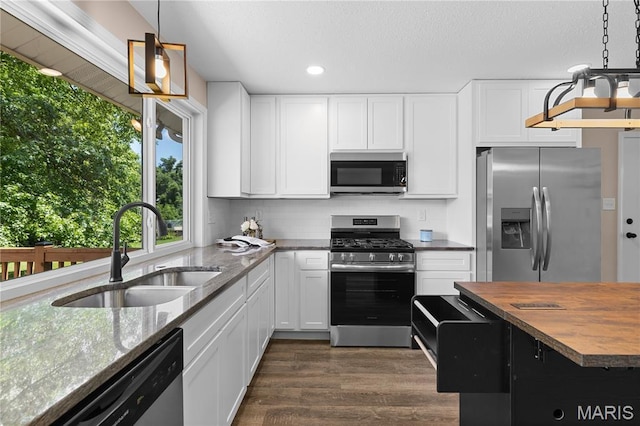 1618 Clock Tower Dr, Saint Louis, MO 63138 - kitchen featuring stainless steel appliances, wooden counters, dark wood finished floors, recessed lighting, and white cabinets