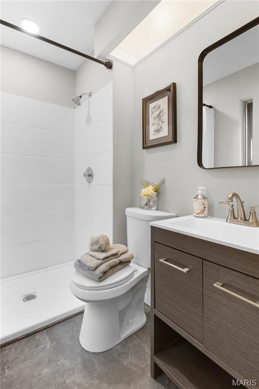 1618 Clock Tower Dr, Saint Louis, MO 63138 - full bathroom featuring vanity, tiled shower, and concrete floors