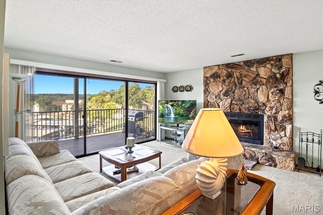 40 Robinwood Unit 2C, Lake Ozark, MO 65049 - living area featuring carpet, a stone fireplace, a textured ceiling, and plenty of natural light