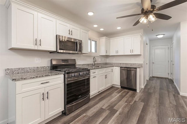 5 Lakeshore Dr, New Baden, IL 62265 - kitchen with stainless steel appliances, white cabinetry, light stone counters, dark wood-style floors, and a ceiling fan