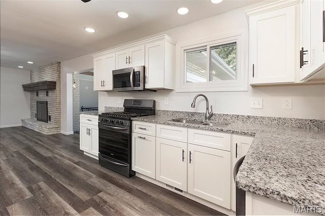 5 Lakeshore Dr, New Baden, IL 62265 - kitchen featuring stainless steel microwave, black range with gas stovetop, dark wood-type flooring, white cabinets, and light stone counters