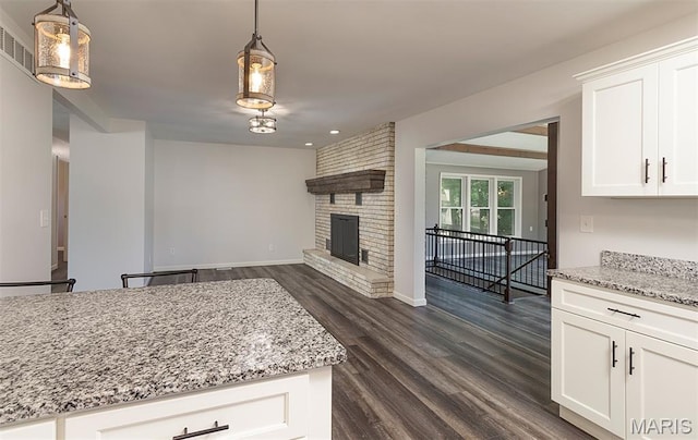 5 Lakeshore Dr, New Baden, IL 62265 - kitchen featuring dark wood-type flooring, light stone counters, open floor plan, white cabinets, and decorative light fixtures