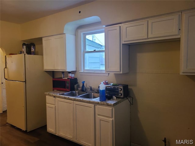 419 Garrison Ave, Cahokia, IL 62206 - kitchen with freestanding refrigerator, stainless steel microwave, dark wood finished floors, and white cabinets
