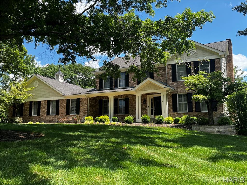 2032 Wilson Ridge Ln, Chesterfield, MO 63005 - view of front of house with a front lawn, a chimney, and brick siding