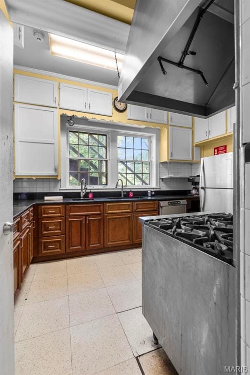 325 N Spring St, Cape Girardeau, MO 63701 - kitchen featuring custom exhaust hood, stainless steel appliances, dark countertops, decorative backsplash, and brown cabinetry
