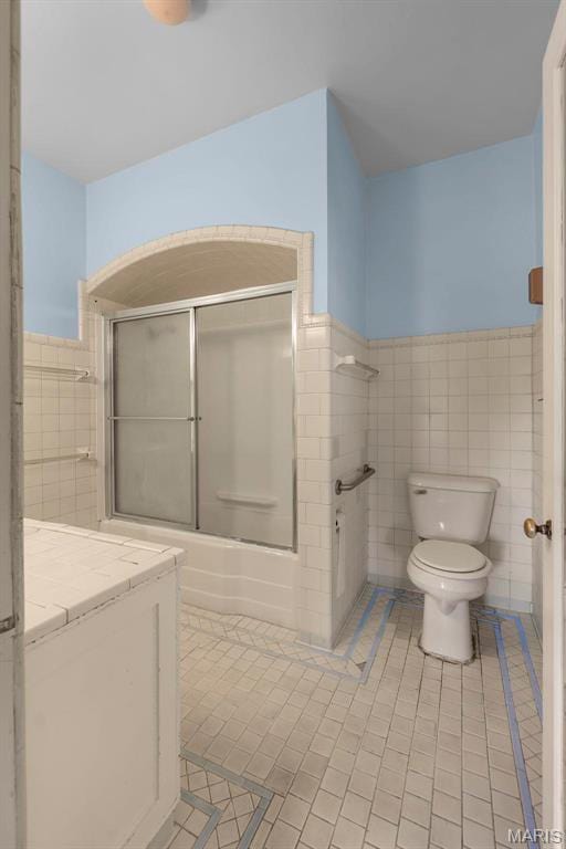 325 N Spring St, Cape Girardeau, MO 63701 - full bathroom featuring tile walls, tile patterned floors, combined bath / shower with glass door, wainscoting, and vanity