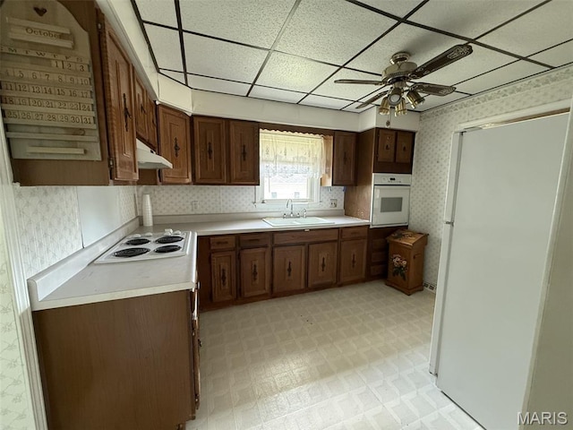 1220 W Edwards St, Vandalia, IL 62471 - kitchen featuring white appliances, wallpapered walls, under cabinet range hood, light flooring, and light countertops