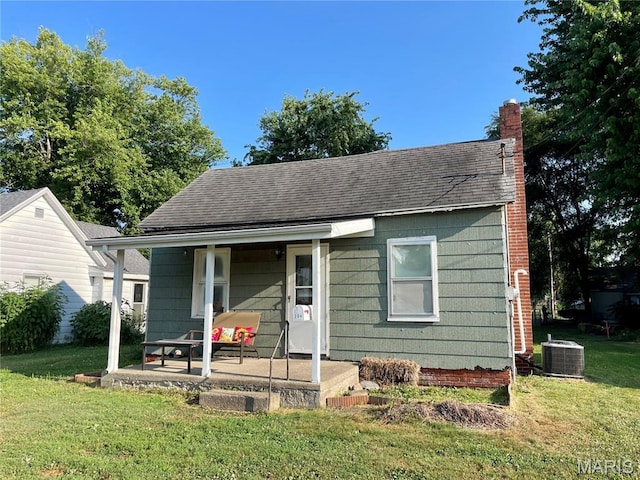 204 E Columbia St, Litchfield, IL 62056 - bungalow featuring a porch, a front yard, a chimney, and a shingled roof