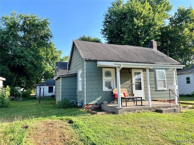 204 E Columbia St, Litchfield, IL 62056 - view of front of house featuring a chimney, a front yard, and a shingled roof