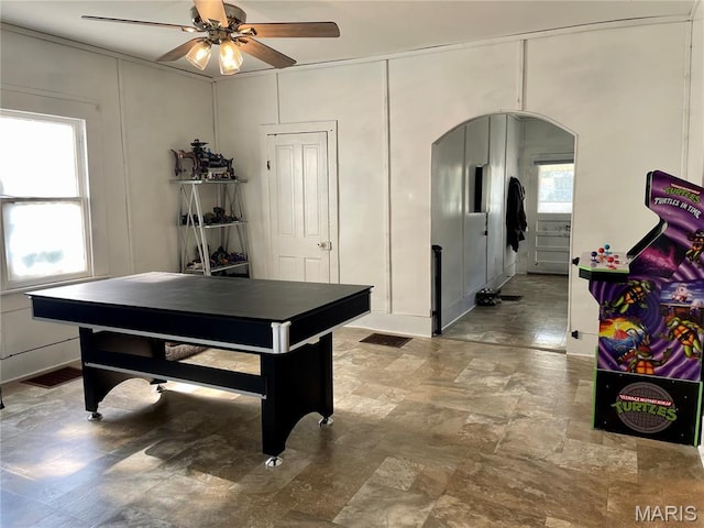 204 E Columbia St, Litchfield, IL 62056 - playroom with arched walkways, a ceiling fan, plenty of natural light, a decorative wall, and stone finish flooring