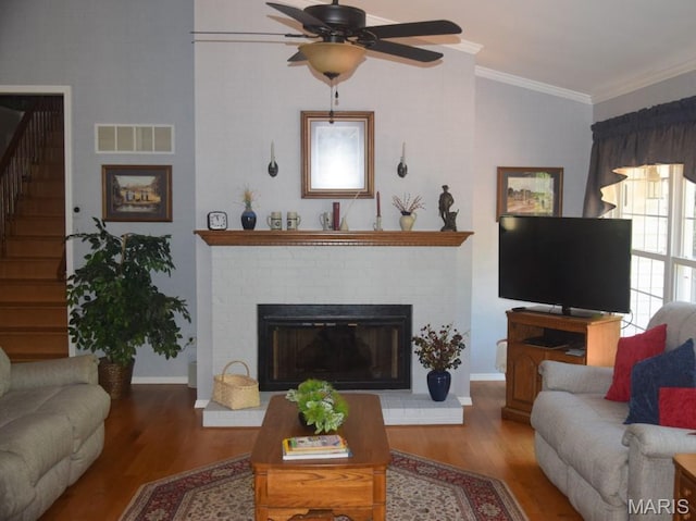 1741 Ivy Chase Ct, Fenton, MO 63026 - living room featuring wood finished floors, stairway, a ceiling fan, a brick fireplace, and crown molding