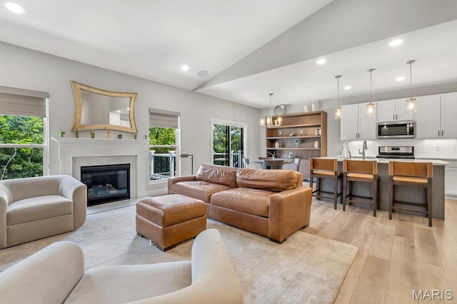 845 Kingston Hills Ct, Fenton, MO 63026 - living area featuring lofted ceiling, recessed lighting, light wood-style floors, and a glass covered fireplace