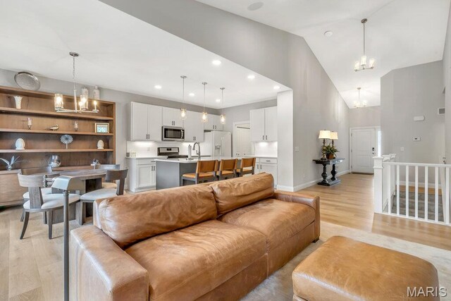 845 Kingston Hills Ct, Fenton, MO 63026 - living room with a chandelier, light wood-type flooring, high vaulted ceiling, and recessed lighting