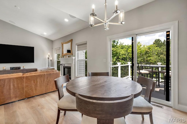 845 Kingston Hills Ct, Fenton, MO 63026 - dining room with a chandelier, light wood-type flooring, lofted ceiling, a glass covered fireplace, and recessed lighting
