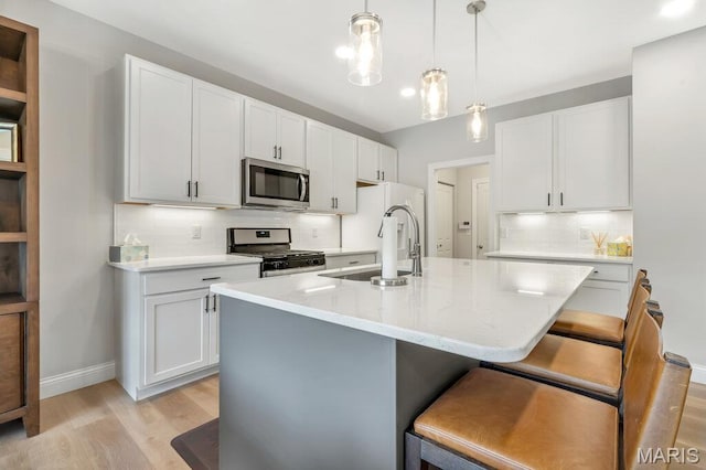 845 Kingston Hills Ct, Fenton, MO 63026 - kitchen featuring stainless steel appliances, backsplash, light wood-style floors, a breakfast bar, and an island with sink