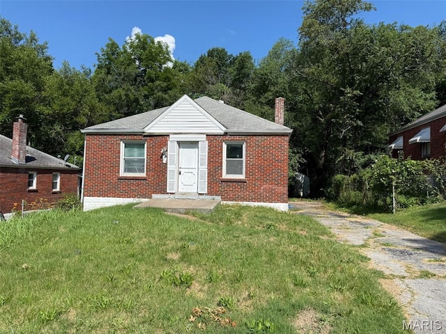 5411 Fletcher St, Jennings, MO 63136 - bungalow-style home featuring a front yard, brick siding, and a chimney