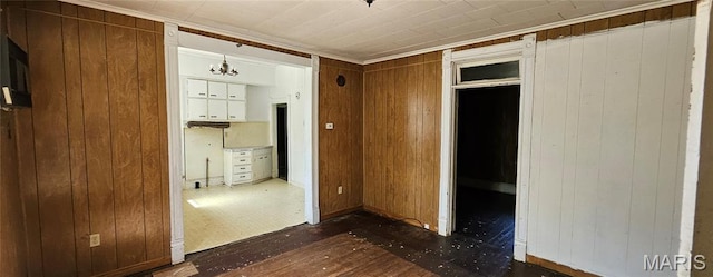 718 2nd St W, Scott City, MO 63780 - unfurnished bedroom featuring wood walls, ornamental molding, and a chandelier