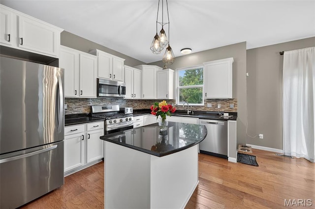 907 Wilderness Way Dr, Eureka, MO 63025 - kitchen featuring appliances with stainless steel finishes, backsplash, white cabinets, light wood-type flooring, and pendant lighting