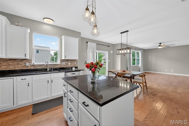 907 Wilderness Way Dr, Eureka, MO 63025 - kitchen with backsplash, white cabinetry, ceiling fan, a kitchen island, and decorative light fixtures